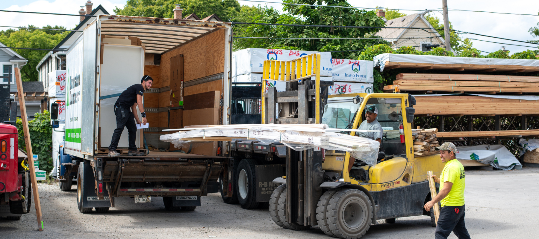 Evanston staff unloading lumber out of a truck with a forklift